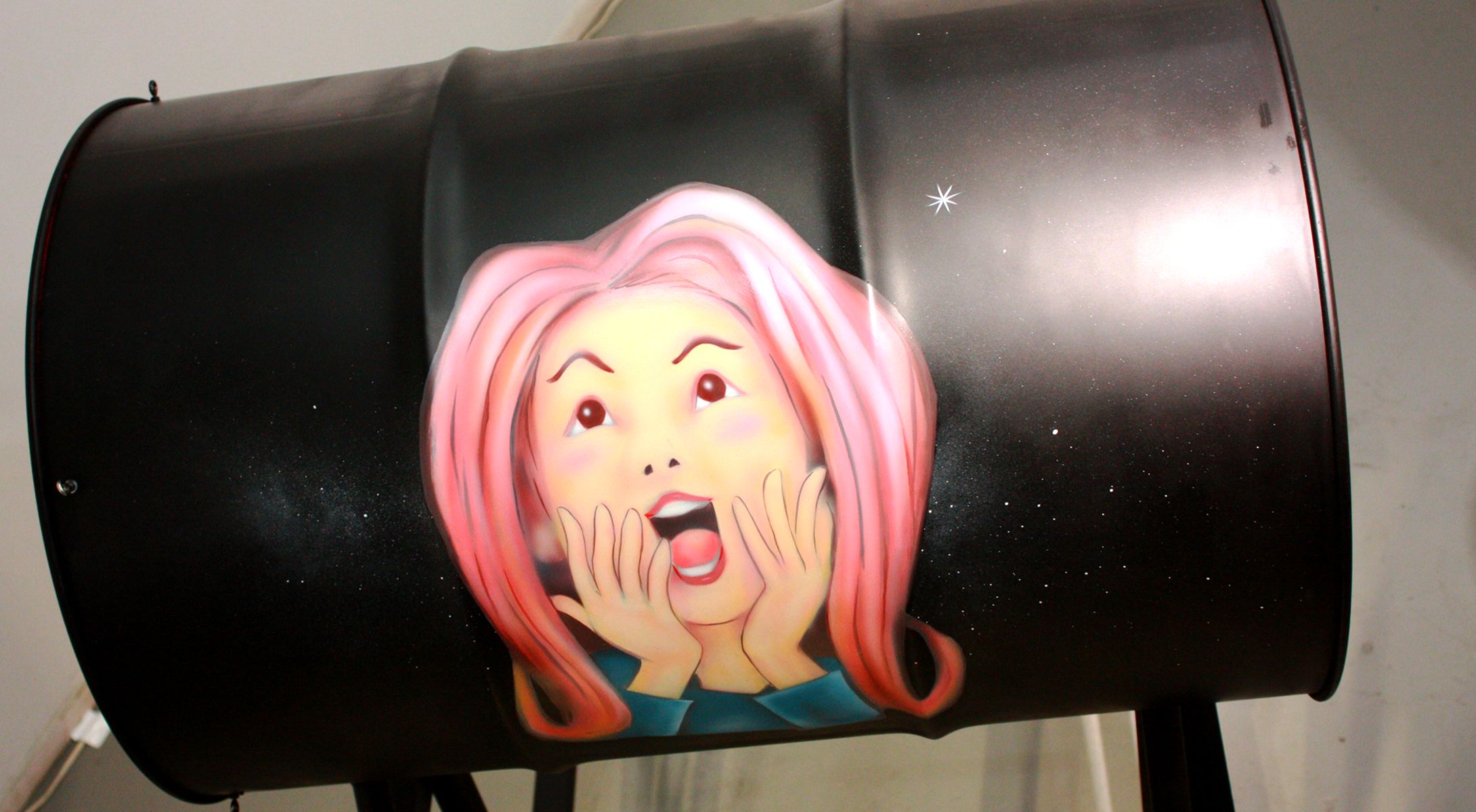 何かに驚いている女性の顔が描かれているドラム缶