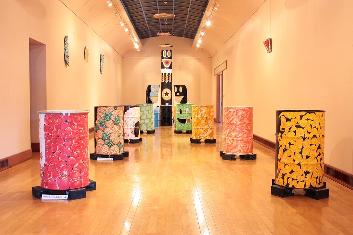 美術館にカラフルにペイントされたドラム缶がいっぱいある