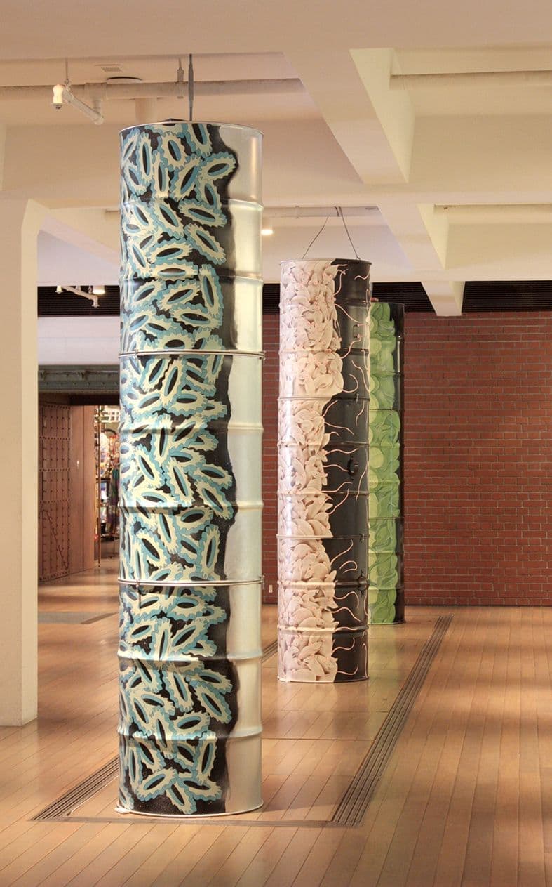 歯車やネズミの描かれたドラムカンが積み重なっている